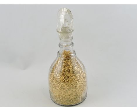A 19th century decanter, containing a quantity of gold leaf scraps.