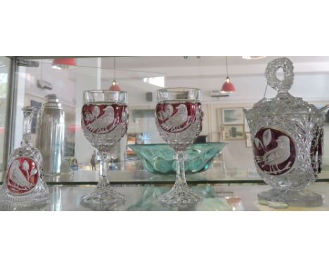 A Bohemian ruby overlaid glass jar and cover, etched with a songbird; together with a pair of matching wines and a table bell
