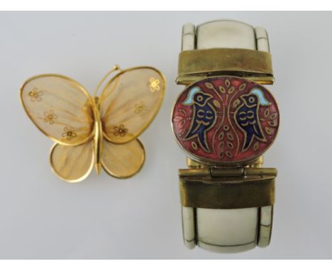 A bone bangle incorporating an enamelled oval box, together with a gilt filigree butterfly, (2).
