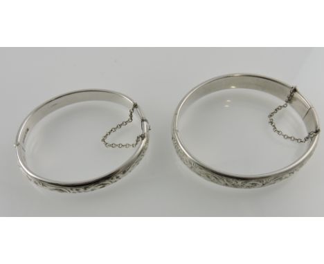A silver bangle, Charles Horner, Chester 1953, engraved with foliage, together with another similar, 31g.