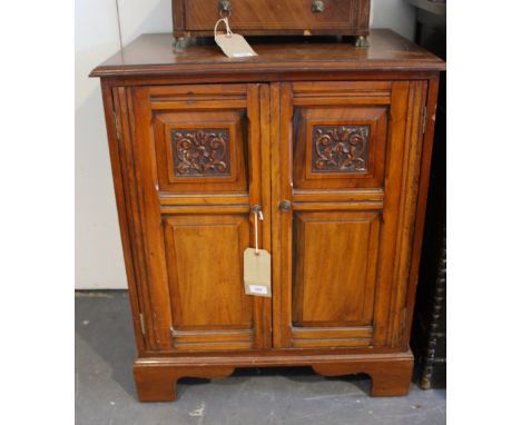 An Edwardian walnut side cabinet, the rectangular moulded top above an arrangement of carved panel doors, on shaped bracket f