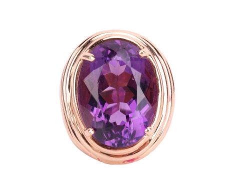 A large amethyst cocktail ring, centred with an oval-cut amethyst approximately measuring 20.1 x 15.1 x 10.6 mm, claw-set to 