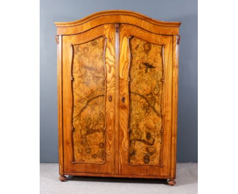 A 19th Century Continental Ash Armoire, with arched and moulded cornice, fitted one shelf enclosed by a pair of shaped doors 