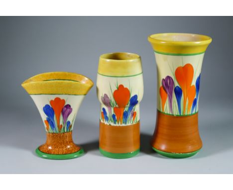 Crocus, Three Clarice Cliff Bizarre Vases, painted in colours between yellow and brown bands, vase shape no.205, 8.25ins high