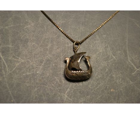 A silver viking longboat and pendant and chain