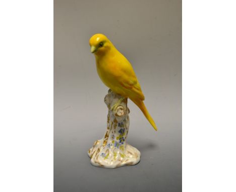 A Royal Worcester model of a yellow canary, perched on a stylized trunk picked out in gilt, model no. 2663, puce printed mark