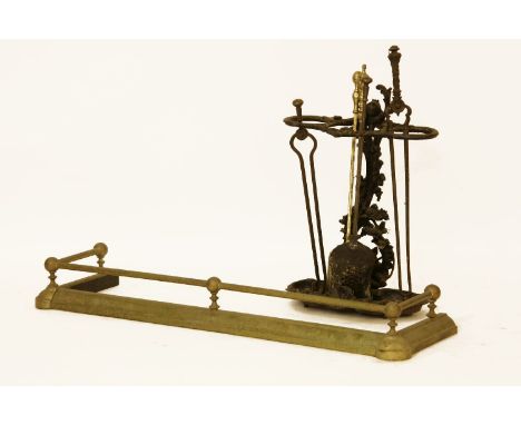 A cast iron stick stand, together with assorted 19th century and later fire irons, and a brass fender