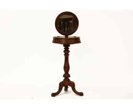 A Victorian walnut shaving stand, the circular mirror on turned support and on tripod base, 130cm tall