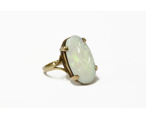 A single stone oval cabochon opal ring, claw set to a split shoulders, on a plain polished shank, marked 9ct3.35g