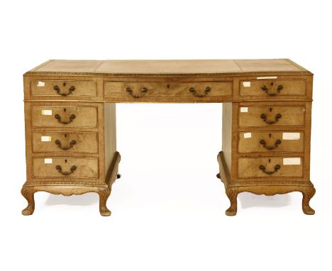 An early 20th century walnut Chippendale style desk, the leather inset top over serpentine front, over pedestals containing a
