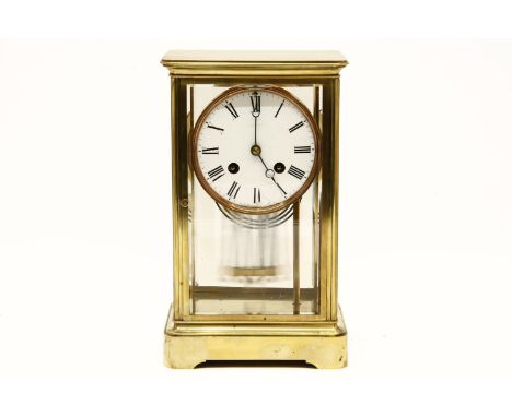 An early 20th century brass and four glass mantel clock, with white enamel dial and black Roman numerals, fitted with Japy Fr