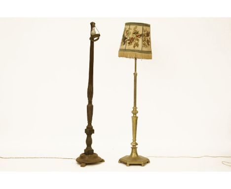 A brass standard lamp, together with a ribbed oak standard lamp  and a mahogany oval mirror