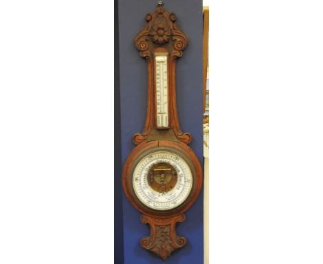 An early 20th century oak cased aneroid barometer, with ceramic dial and inset thermometer and inscription plaque, 90cm overa