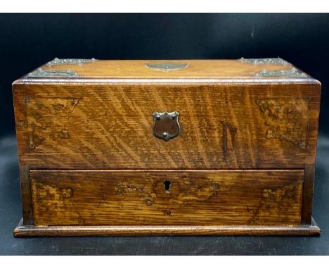 An oak tea caddy with sliding drawers and white metal detail.