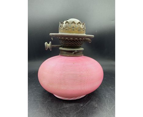 A Hinks oil lamp with a pink candy stripe glass base 