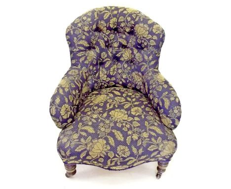 A Victorian button back upholstered armchair on turned supports