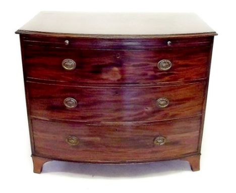 An early 19th century mahogany bow fronted chest of two short and three long drawers with brushing slide and bracket supports