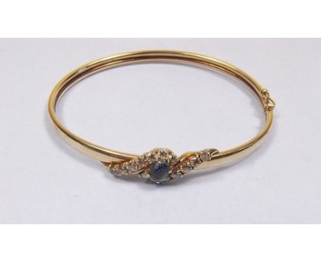 A 9 carat gold bangle set blue topaz and white paste