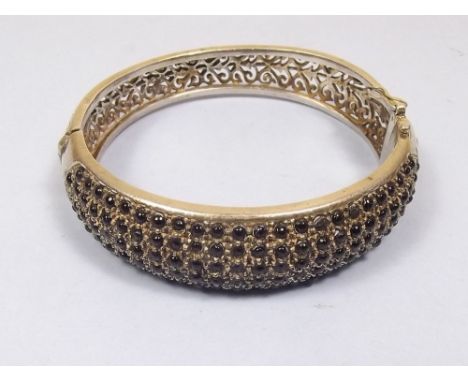 A silver hinged bangle set stones and with pierced decoration 