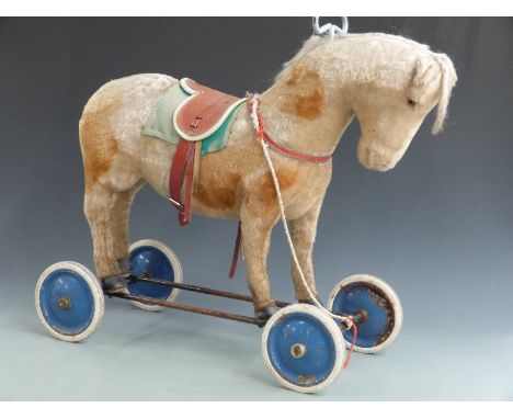 Steiff ride on horse on wheels with shaved spotted mohair, leather saddle, blue metal wheels and original button and label to
