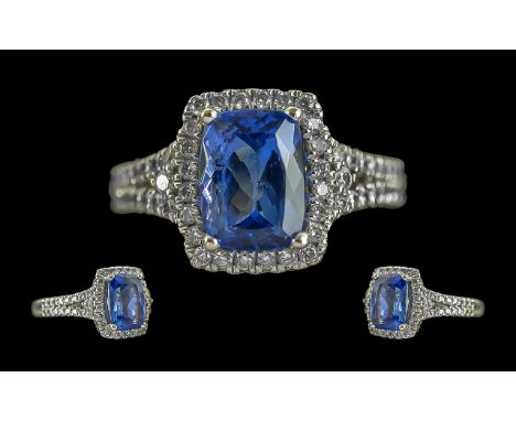 Ladies 14ct White Gold Diamond And Tanzanite Set Dress Ring. Marked 14ct to Interior of Shank. The Central Step-cut Blue Tanz