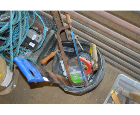 A plastic bucket of various hand tools 
