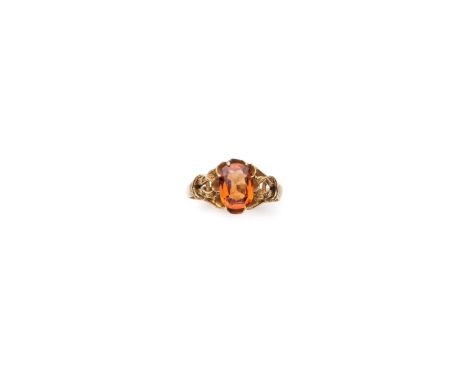 GARNET RING, LATE 19TH CENTURY the cushion shaped hessonite garnet mounted between engraved buckle motif shoulders size L 1/2