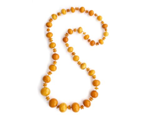 LONG AMBER NECKLACE the row of thirty one large spherical, oval or bun-shaped beads, measuring from 30.4mm to 5.4mm approxima