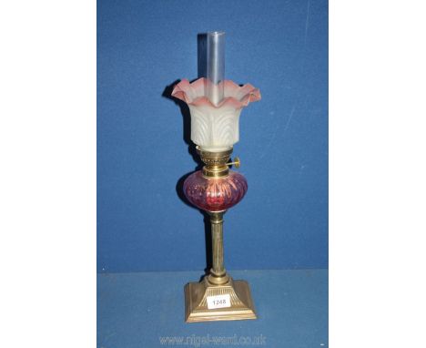 An Oil lamp on reeded column with square base, cranberry glass reservoir and frosted glass shade, 18 1/2" tall.