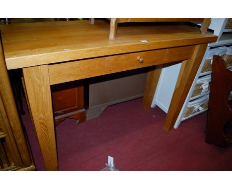 A contemporary light oak single drawer side table raised on square cut tapering supports, width 120cm