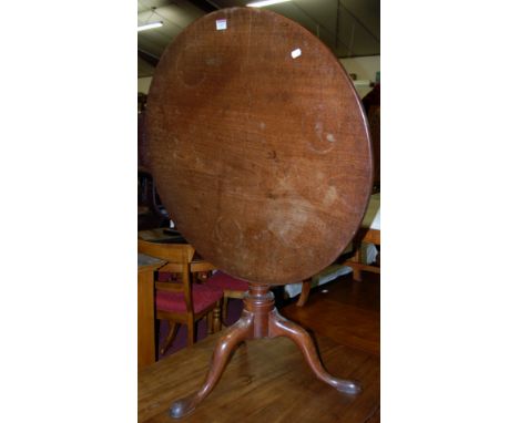 A George III mahogany circular tilt-top pedestal tripod table, having birdcage action, dia. 77cm