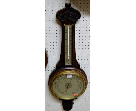 A mid 20th century carved oak two dial aneroid wheel barometer