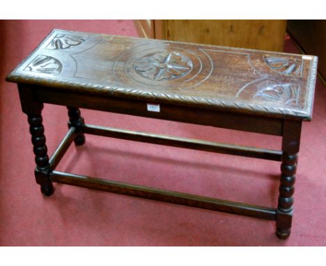An early 20th century line carved oak twin stool raised on bobbin turned supports, width 76cm
