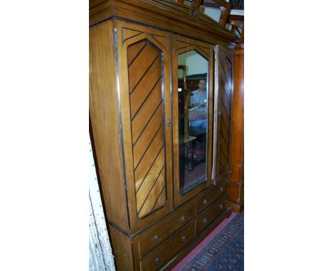 A late Victorian ash three door wardrobe, having central lancet arched mirror door over base fitted with four drawers, width 