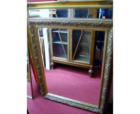 A large modern gilt framed bevelled rectangular wall mirror, together with one other slightly smaller example, and one other 
