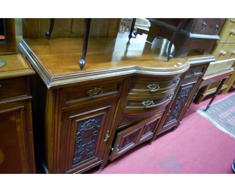 An Edwardian low relief carved walnut sideboard having bow front centre