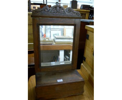 An oak hanging bathroom mirror having hinged compartment