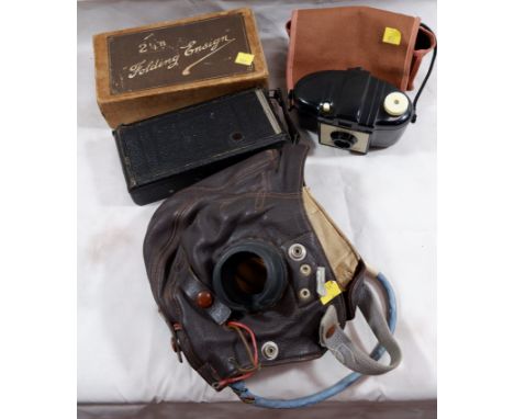 A WWI leather flying helmet; vintage folding Ensign camera and a Brownie camera