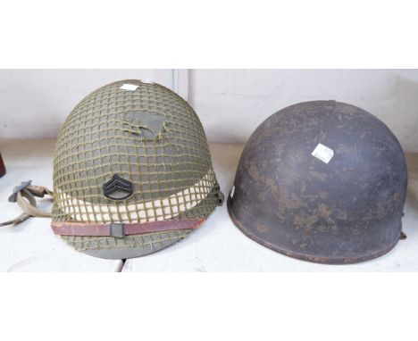 A WWII M1 helmet, webbing marked Joe R. McBride 38211325, another steel helmet