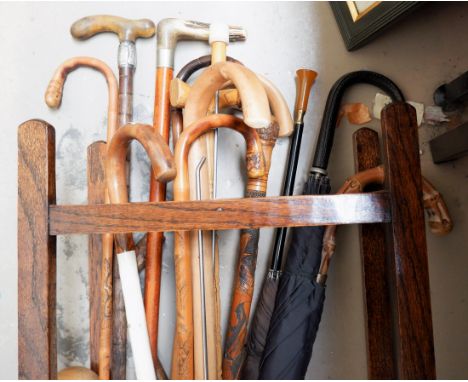 A 1930's oak stick stand and a collection of sticks including a Chinese carved bamboo stick, silver mounted sticks etc