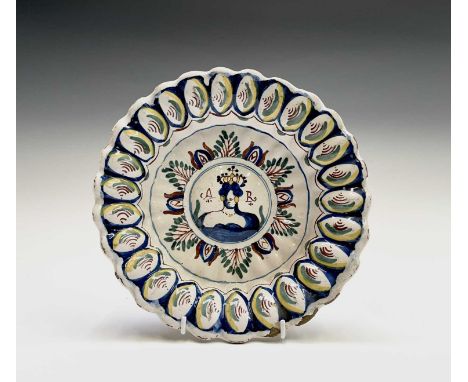An English delft polychrome decorated lobed dish, probably Bristol, circa 1710, with royal portrait of Queen Anne, initialled