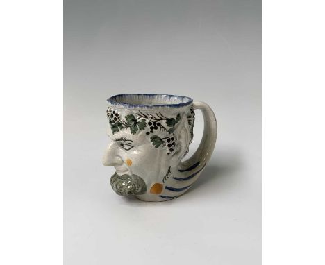 An English pearlware satyr jug, early 19th century, decorated in Pratt colours, height 8.7cm, width 6.7cm, depth 11cm.Provena
