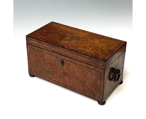 An early 19th century burr walnut tea caddy, the interior fitted with a glass mixing and two hinged compartments, on bun feet