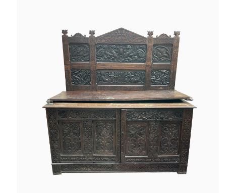 An oak cupboard, with a carved back, the base incorporating panels from a 17th century coffer, altered in the 19th century, i