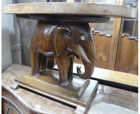 An Indian teak oval occasional table, raised on carved standing elephant pedestal to stepped base, length 80.5cmRight hand tu