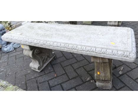 A reconstituted stone two-seater garden bench seat, raised on floral scroll pedestal end supports, length 114cm