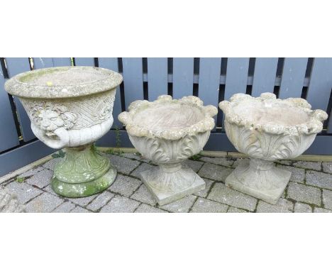 A pair of reconstituted stone pedestal leaf decorated footed garden planters, each dia. 50cm, together with a further single 