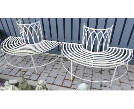 A painted iron strapwork garden tree bench of typical cylindrical form, comprised of two parts, dia. 132cm