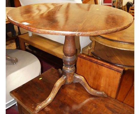 An 18th century provincial fruitwood topped and oak based circular tilt-top pedestal tripod table, raised on hipped supports,