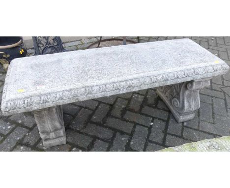 A reconstituted stone garden twin bench seat, raised on scroll pedestal end supports, length 114cm